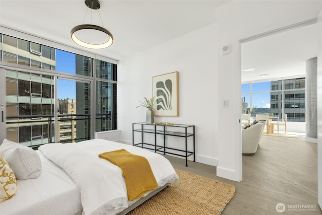 2033 2nd Ave Unit 1111, Seattle, WA 98121 - bedroom featuring a wall of windows, wood finished floors, and a view of city