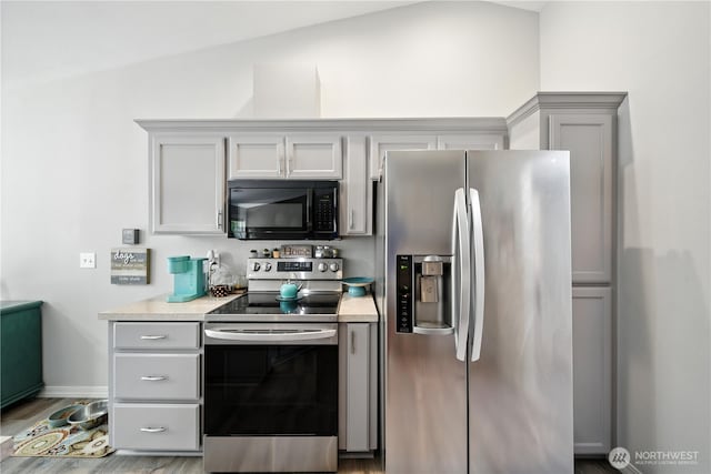 2322 Garrison St, Walla Walla, WA 99362 - kitchen with stainless steel appliances, gray cabinetry, light countertops, lofted ceiling, and light wood finished floors