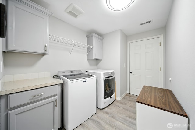 2322 Garrison St, Walla Walla, WA 99362 - laundry room with washing machine and clothes dryer, light wood-style floors, and cabinet space