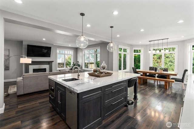 1416 2nd St, Kirkland, WA 98033 - kitchen with recessed lighting, stainless steel dishwasher, dark wood-type flooring, a fireplace, and light stone counters