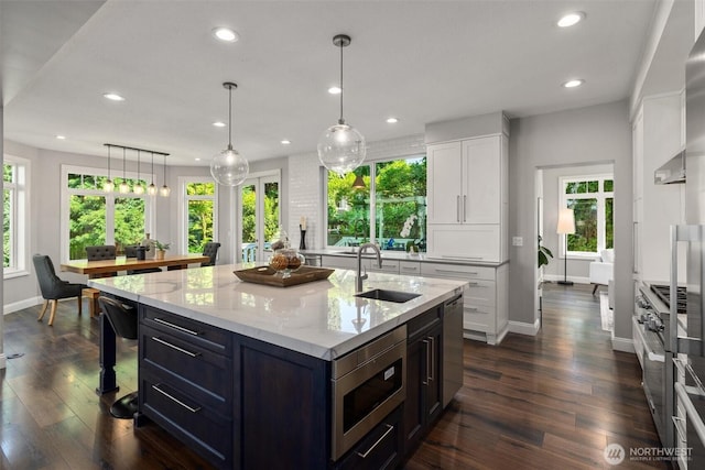 1416 2nd St, Kirkland, WA 98033 - kitchen featuring stainless steel appliances, recessed lighting, white cabinetry, light stone counters, and an island with sink