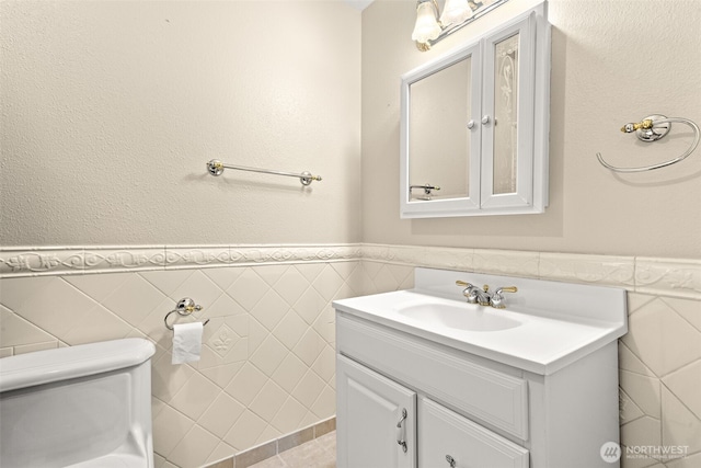 7523 13th Ave SE, Lacey, WA 98503 - bathroom with vanity, tile walls, and a wainscoted wall