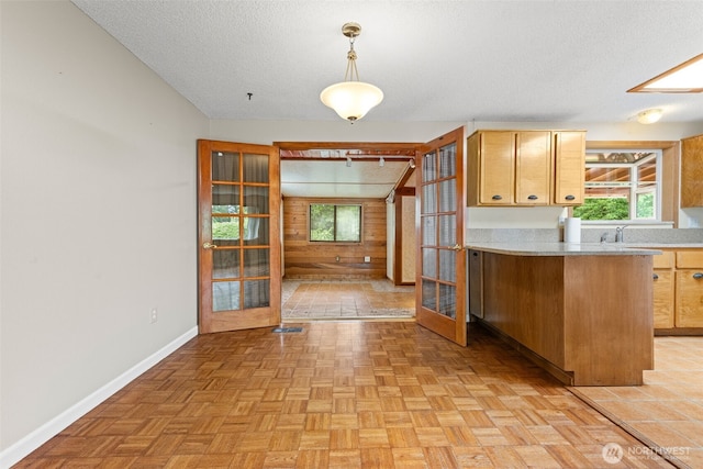 7523 13th Ave SE, Lacey, WA 98503 - kitchen featuring light countertops, wood walls, french doors, a peninsula, and a textured ceiling