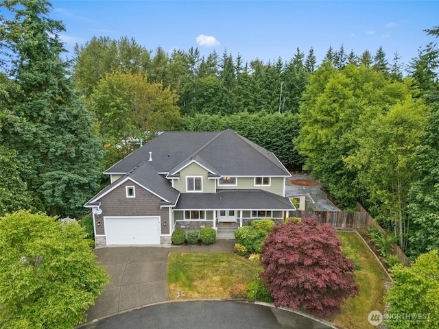 1402 180th Ave E, Lake Tapps, WA 98391 - view of front of house with concrete driveway, stone siding, covered porch, and a view of trees