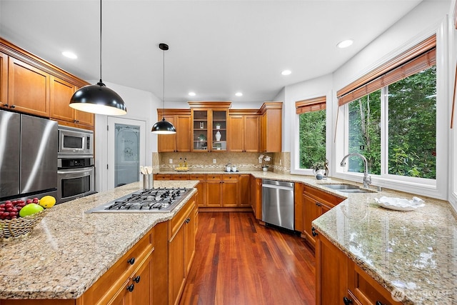 1402 180th Ave E, Lake Tapps, WA 98391 - kitchen with appliances with stainless steel finishes, brown cabinetry, glass insert cabinets, light stone countertops, and recessed lighting