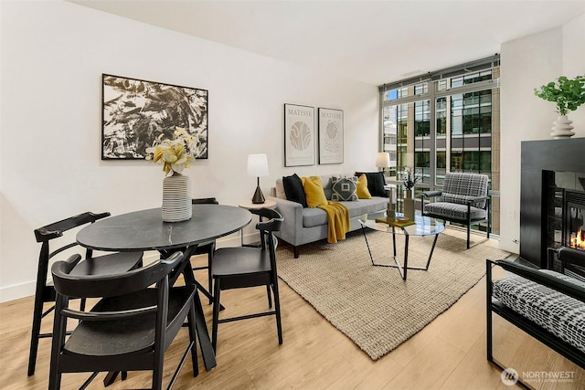 819 Virginia St Unit 1606, Seattle, WA 98101 - living area featuring floor to ceiling windows, wood finished floors, and a glass covered fireplace