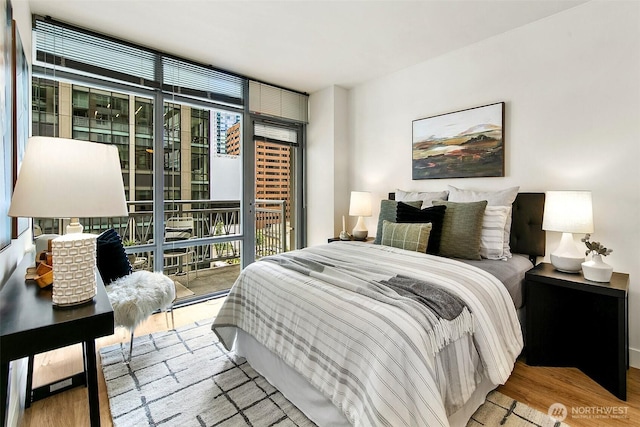 819 Virginia St Unit 1606, Seattle, WA 98101 - bedroom featuring a wall of windows, access to outside, multiple windows, and wood finished floors