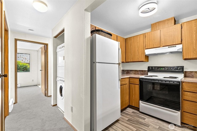 17521 118th Ave SE Unit A-4, Renton, WA 98058 - kitchen with white appliances, under cabinet range hood, stacked washer / drying machine, and brown cabinets