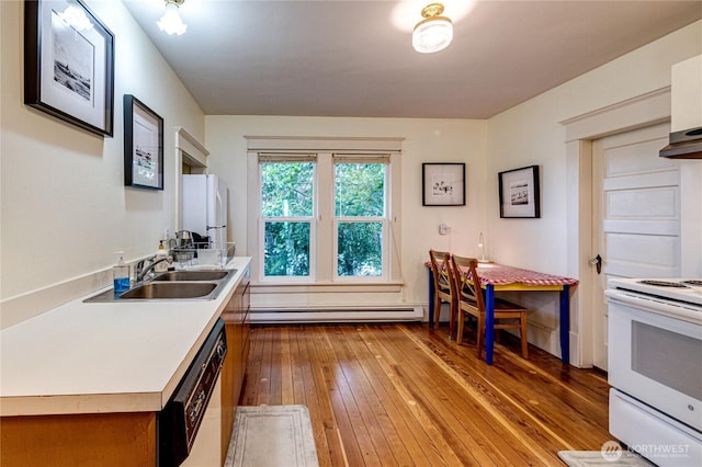 231 E 1st St, Port Angeles, WA 98362 - kitchen with hardwood / wood-style floors, light countertops, white appliances, a baseboard radiator, and extractor fan