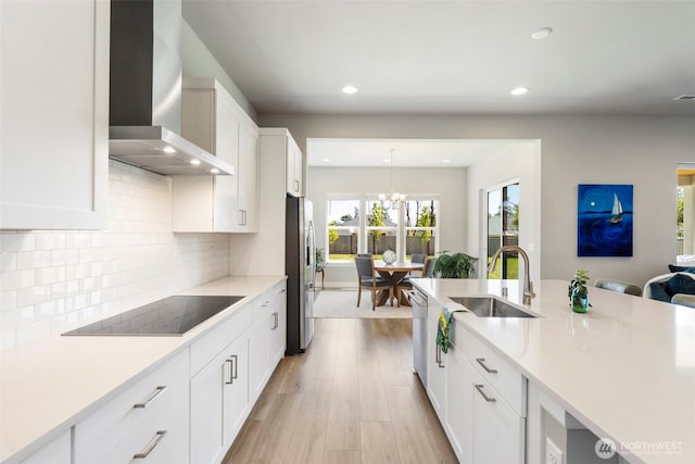 4490 Albatross St, Port Townsend, WA 98368 - kitchen with wall chimney range hood, stainless steel appliances, recessed lighting, light countertops, and white cabinets