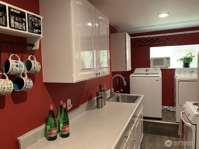 5910 21st Ave SW, Seattle, WA 98106 - kitchen featuring white appliances, washing machine and clothes dryer, white cabinetry, light countertops, and dark wood-style flooring