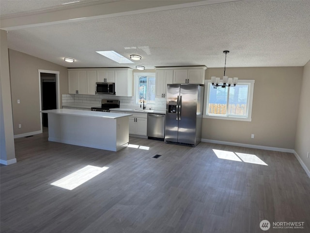 8102 195th St E Unit 95, Spanaway, WA 98387 - kitchen with stainless steel appliances, a chandelier, light countertops, tasteful backsplash, and wood finished floors