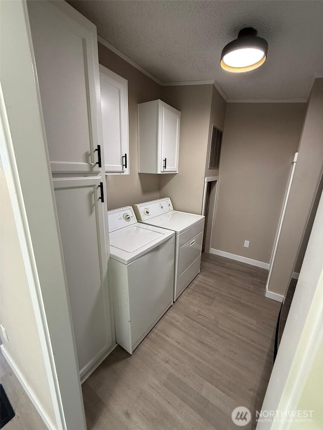8102 195th St E Unit 95, Spanaway, WA 98387 - laundry room with separate washer and dryer, cabinet space, light wood-style flooring, crown molding, and a textured ceiling