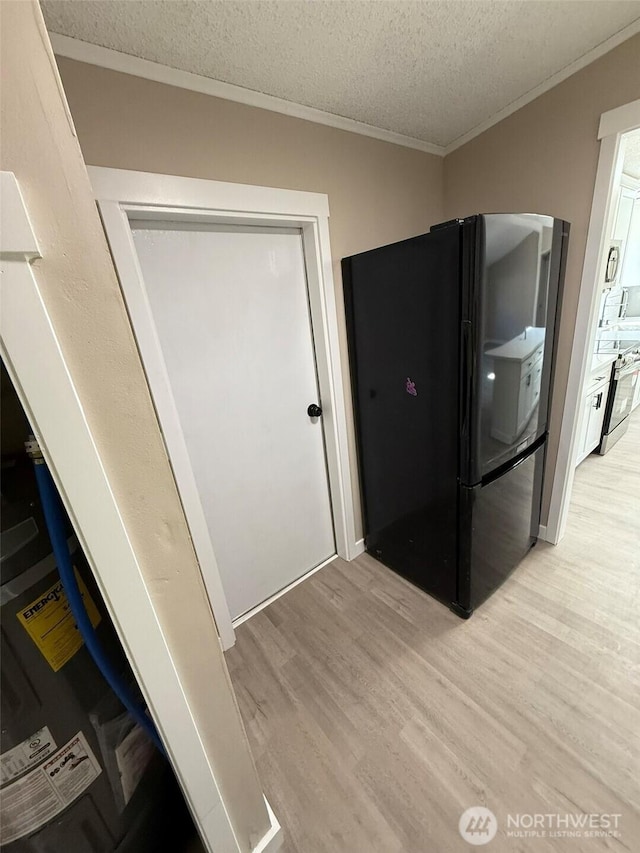 8102 195th St E Unit 95, Spanaway, WA 98387 - kitchen featuring freestanding refrigerator, ornamental molding, light wood finished floors, and a textured ceiling