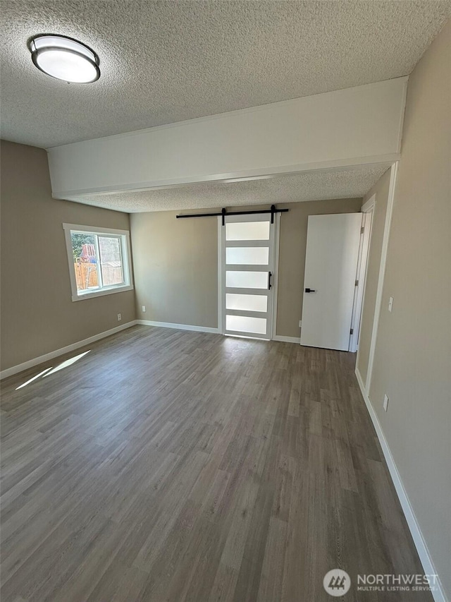 8102 195th St E Unit 95, Spanaway, WA 98387 - spare room with a textured ceiling, wood finished floors, and a barn door
