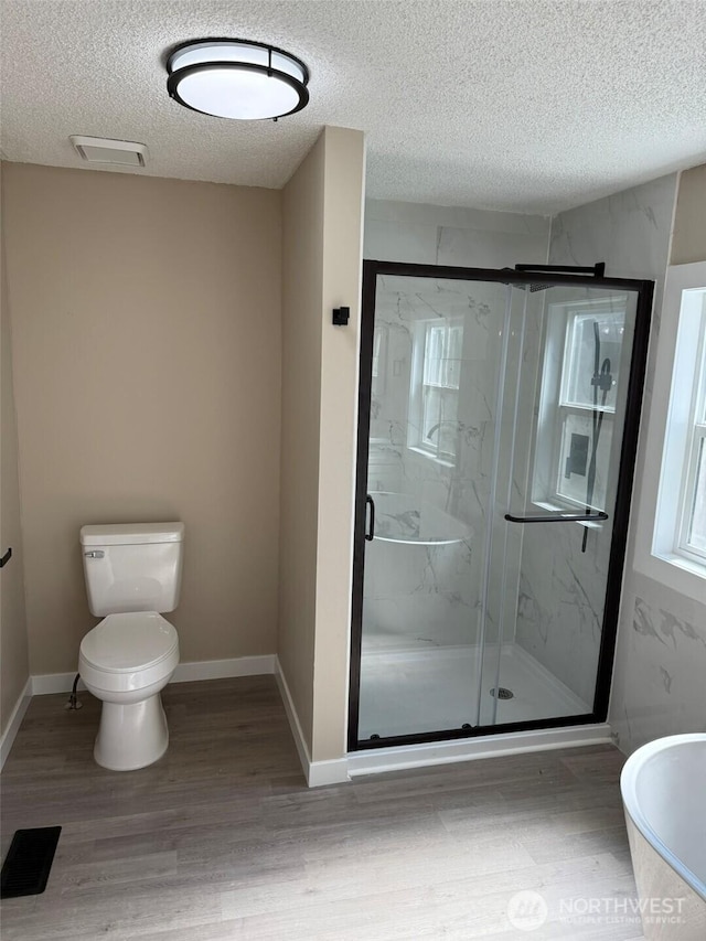 8102 195th St E Unit 95, Spanaway, WA 98387 - full bathroom with a textured ceiling, wood finished floors, a marble finish shower, and a freestanding tub