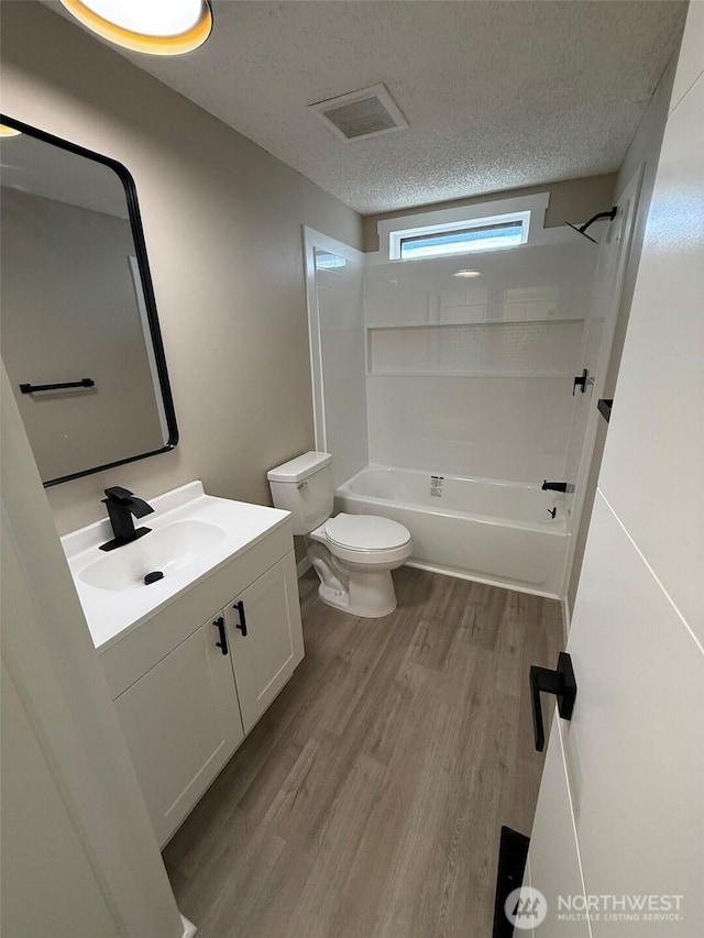 8102 195th St E Unit 95, Spanaway, WA 98387 - bathroom with vanity, wood finished floors, bathing tub / shower combination, and a textured ceiling