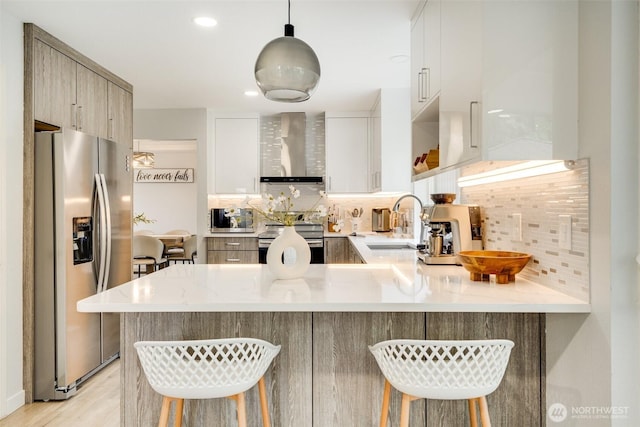 36318 30th Ave S, Federal Way, WA 98003 - kitchen featuring wall chimney exhaust hood, stainless steel appliances, a peninsula, and tasteful backsplash