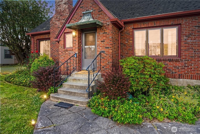 235 S 59th St, Tacoma, WA 98408 - view of front facade with a chimney, a shingled roof, brick siding, and entry steps