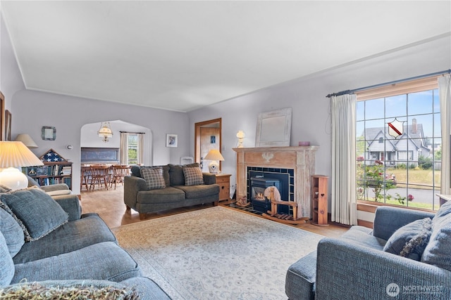235 S 59th St, Tacoma, WA 98408 - living room featuring arched walkways, a tile fireplace, and wood finished floors