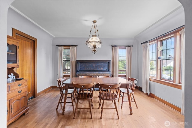 235 S 59th St, Tacoma, WA 98408 - dining area with light wood-style flooring, healthy amount of natural light, a chandelier, arched walkways, and ornamental molding