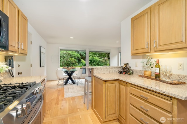 22526 53rd Ave SE, Bothell, WA 98021 - kitchen featuring light wood-style floors, light stone countertops, stainless steel gas range oven, black microwave, and recessed lighting