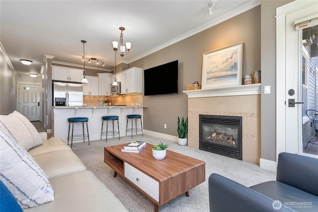 1000 High St Unit 102, Bellingham, WA 98225 - living room with light carpet, crown molding, a fireplace, rail lighting, and a chandelier