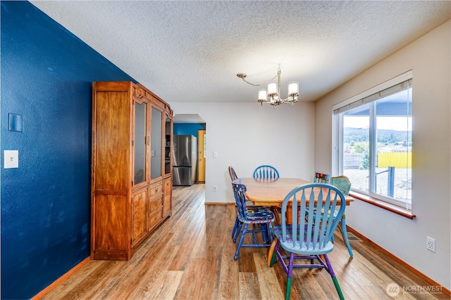541 Salal Pl, Sequim, WA 98382 - dining room with a chandelier, light wood finished floors, and a textured ceiling