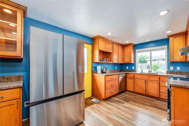 541 Salal Pl, Sequim, WA 98382 - kitchen with appliances with stainless steel finishes, a textured ceiling, light wood finished floors, brown cabinets, and recessed lighting