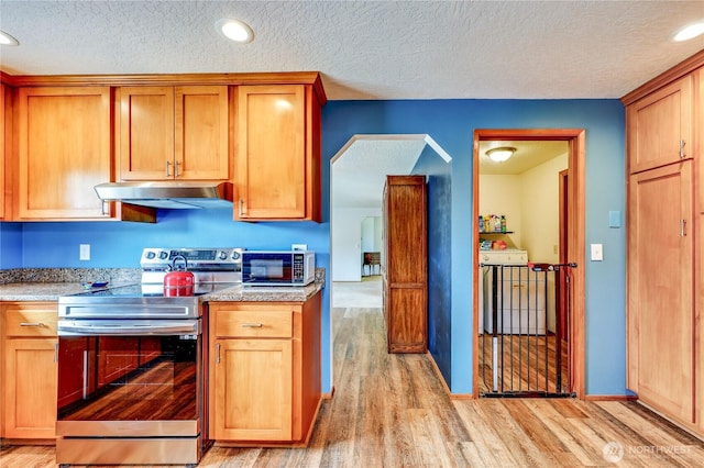 541 Salal Pl, Sequim, WA 98382 - kitchen featuring stainless steel electric range, under cabinet range hood, a textured ceiling, light wood-style floors, and arched walkways