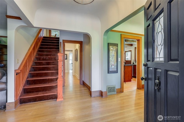 2463 26th Ave E, Seattle, WA 98112 - entrance foyer featuring light wood finished floors, arched walkways, stairs, and healthy amount of natural light