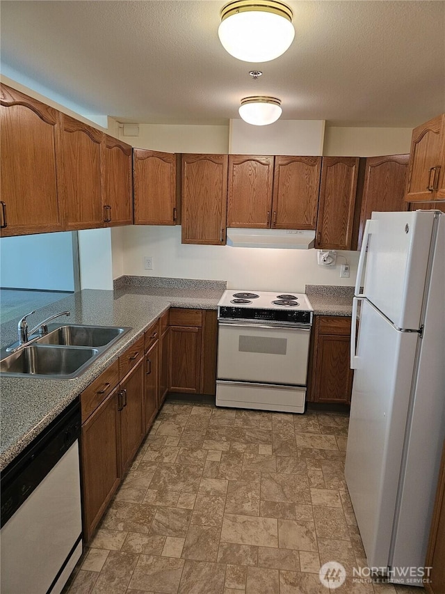 1750 152nd Ave NE Unit C310, Bellevue, WA 98007 - kitchen with white appliances, under cabinet range hood, stone finish floors, and brown cabinets