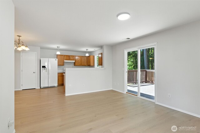 12904 159th St E, Puyallup, WA 98374 - unfurnished living room with light wood-style floors and a chandelier