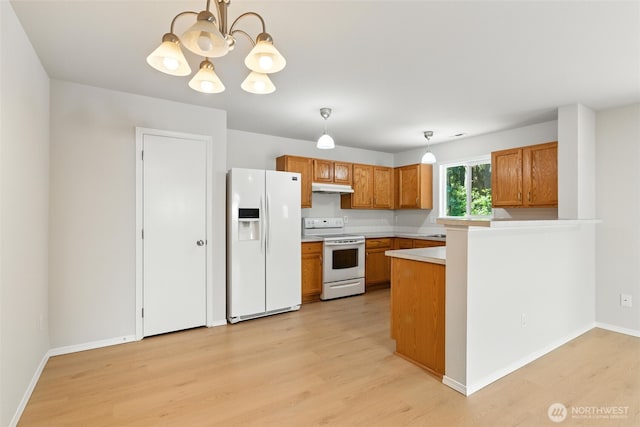 12904 159th St E, Puyallup, WA 98374 - kitchen featuring white appliances, under cabinet range hood, light wood finished floors, and brown cabinetry
