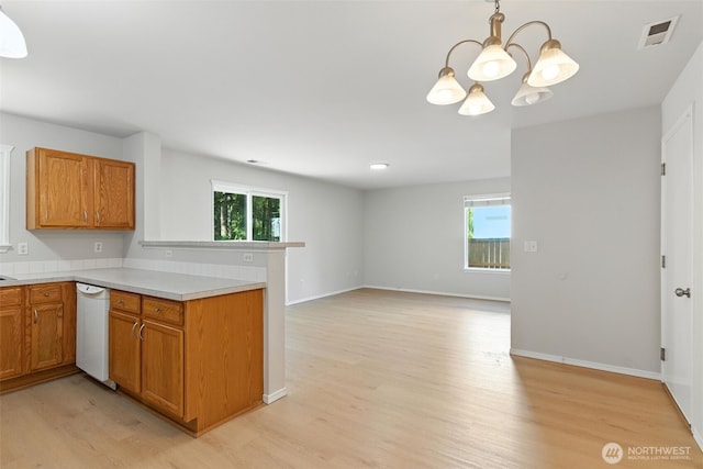 12904 159th St E, Puyallup, WA 98374 - kitchen featuring dishwasher, a chandelier, a peninsula, light wood finished floors, and healthy amount of natural light