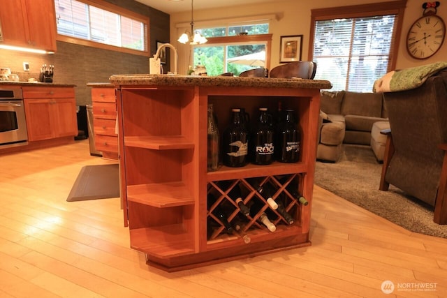4442 Prestwick Ln SE, Lacey, WA 98513 - kitchen with oven, light wood-type flooring, a chandelier, and hanging light fixtures