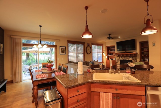 4442 Prestwick Ln SE, Lacey, WA 98513 - kitchen featuring open floor plan, a fireplace, light stone countertops, a chandelier, and stainless steel dishwasher