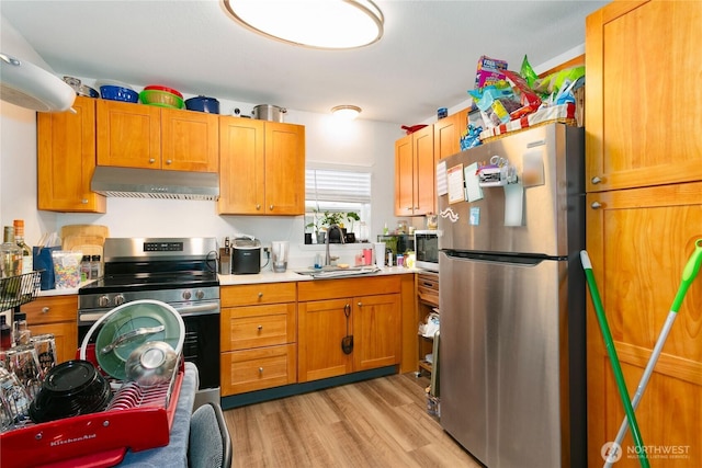 617-619 140th St S, Tacoma, WA 98444 - kitchen featuring appliances with stainless steel finishes, under cabinet range hood, light countertops, and light wood-type flooring
