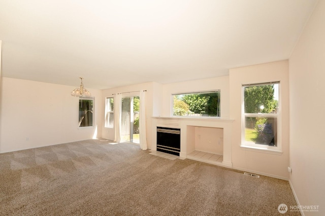 527 Cypress Ave, Snohomish, WA 98290 - unfurnished living room with carpet flooring, plenty of natural light, a tile fireplace, and a chandelier