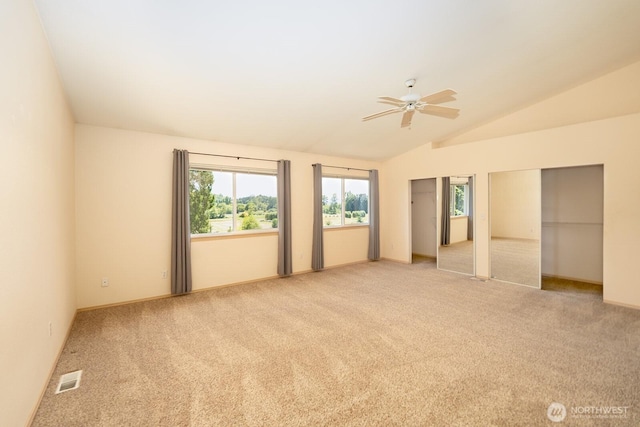 527 Cypress Ave, Snohomish, WA 98290 - unfurnished bedroom featuring two closets, carpet flooring, lofted ceiling, multiple windows, and ceiling fan
