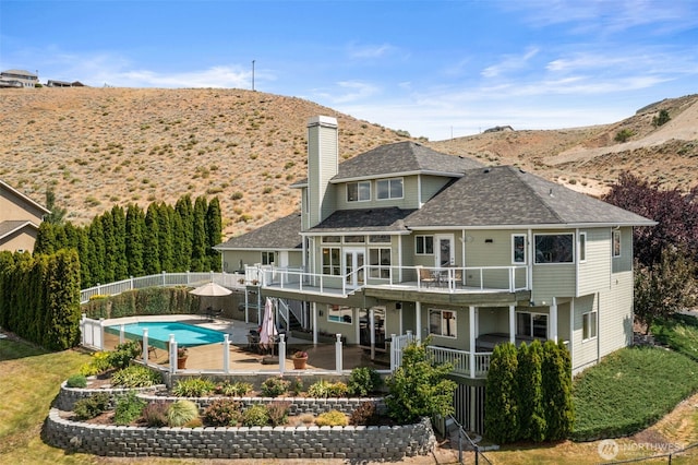 591 Daniels Dr NE, East Wenatchee, WA 98802 - back of house with a chimney, a deck with mountain view, a fenced backyard, a patio area, and roof with shingles
