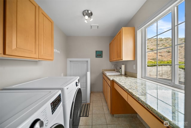 591 Daniels Dr NE, East Wenatchee, WA 98802 - washroom featuring washing machine and clothes dryer, cabinet space, and light tile patterned flooring