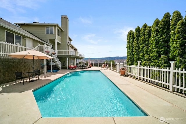 591 Daniels Dr NE, East Wenatchee, WA 98802 - view of swimming pool with stairway, a patio area, and a deck with mountain view