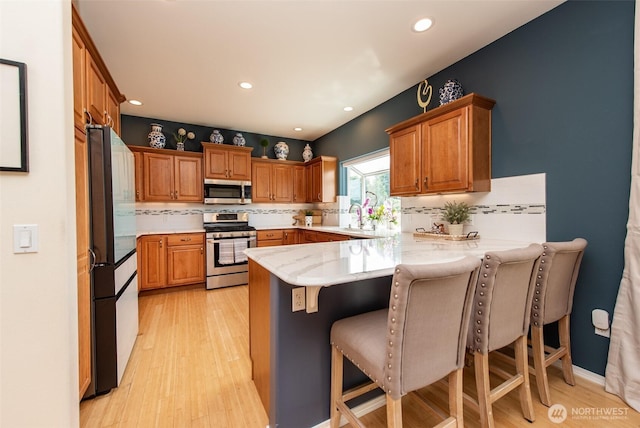 120 Cascadia Loop, Sequim, WA 98382 - kitchen with stainless steel appliances, a peninsula, decorative backsplash, recessed lighting, and a breakfast bar area