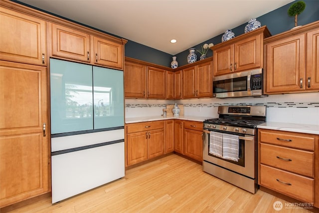 120 Cascadia Loop, Sequim, WA 98382 - kitchen with appliances with stainless steel finishes, light wood-style floors, backsplash, light countertops, and recessed lighting