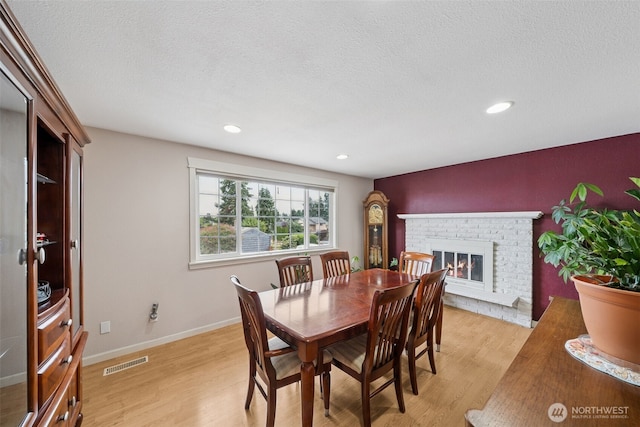 4610 N Defiance St, Tacoma, WA 98407 - dining space with light wood-style flooring, a fireplace, a textured ceiling, and recessed lighting