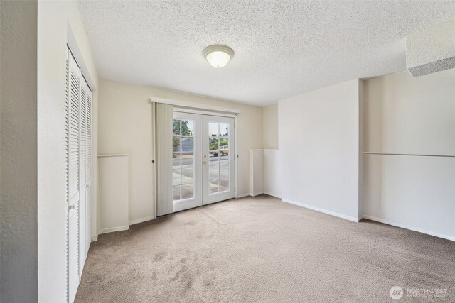 4610 N Defiance St, Tacoma, WA 98407 - unfurnished bedroom featuring french doors, access to exterior, carpet flooring, a textured ceiling, and a closet