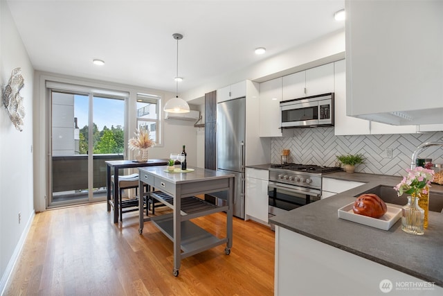 140 26th Ave E, Seattle, WA 98112 - kitchen featuring high quality appliances, dark countertops, white cabinets, tasteful backsplash, and light wood-type flooring