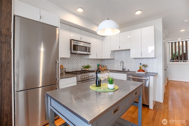 140 26th Ave E, Seattle, WA 98112 - kitchen with appliances with stainless steel finishes, dark countertops, tasteful backsplash, white cabinetry, and recessed lighting
