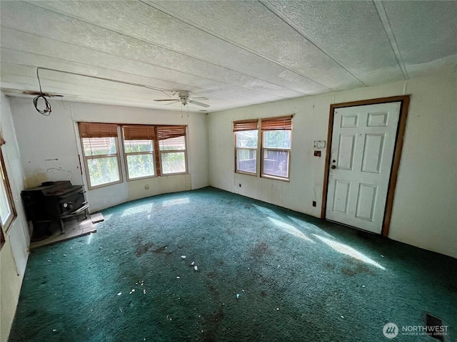 1201 S 2nd St, Dayton, WA 99328 - unfurnished living room with a wood stove, ceiling fan, a textured ceiling, and carpet